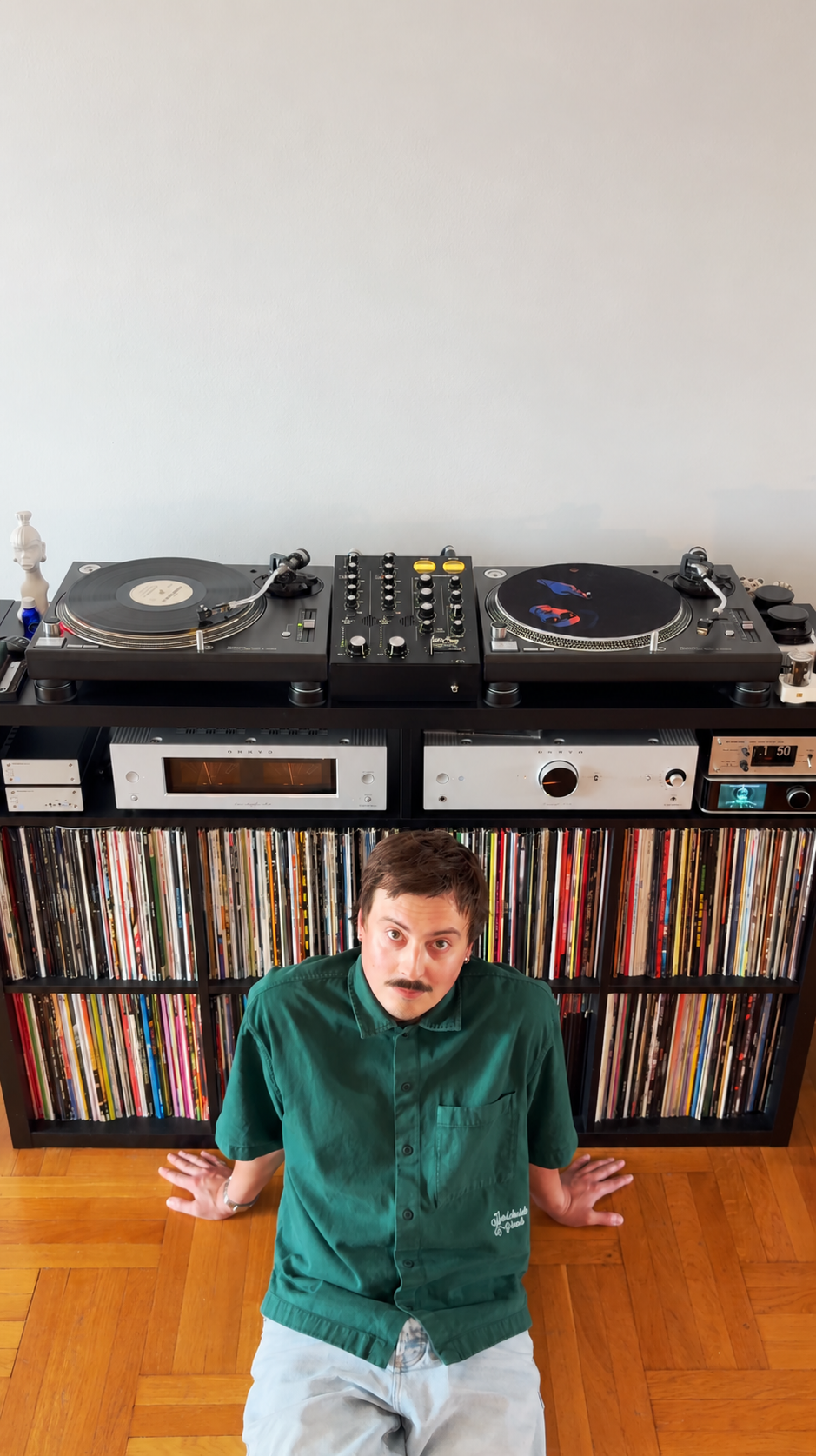 Sam sitting beside his records and hi-fi setup